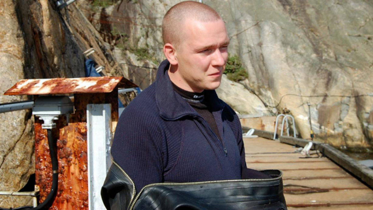 Fredrik Ahlgren står på brygga iförd dykardräkt.