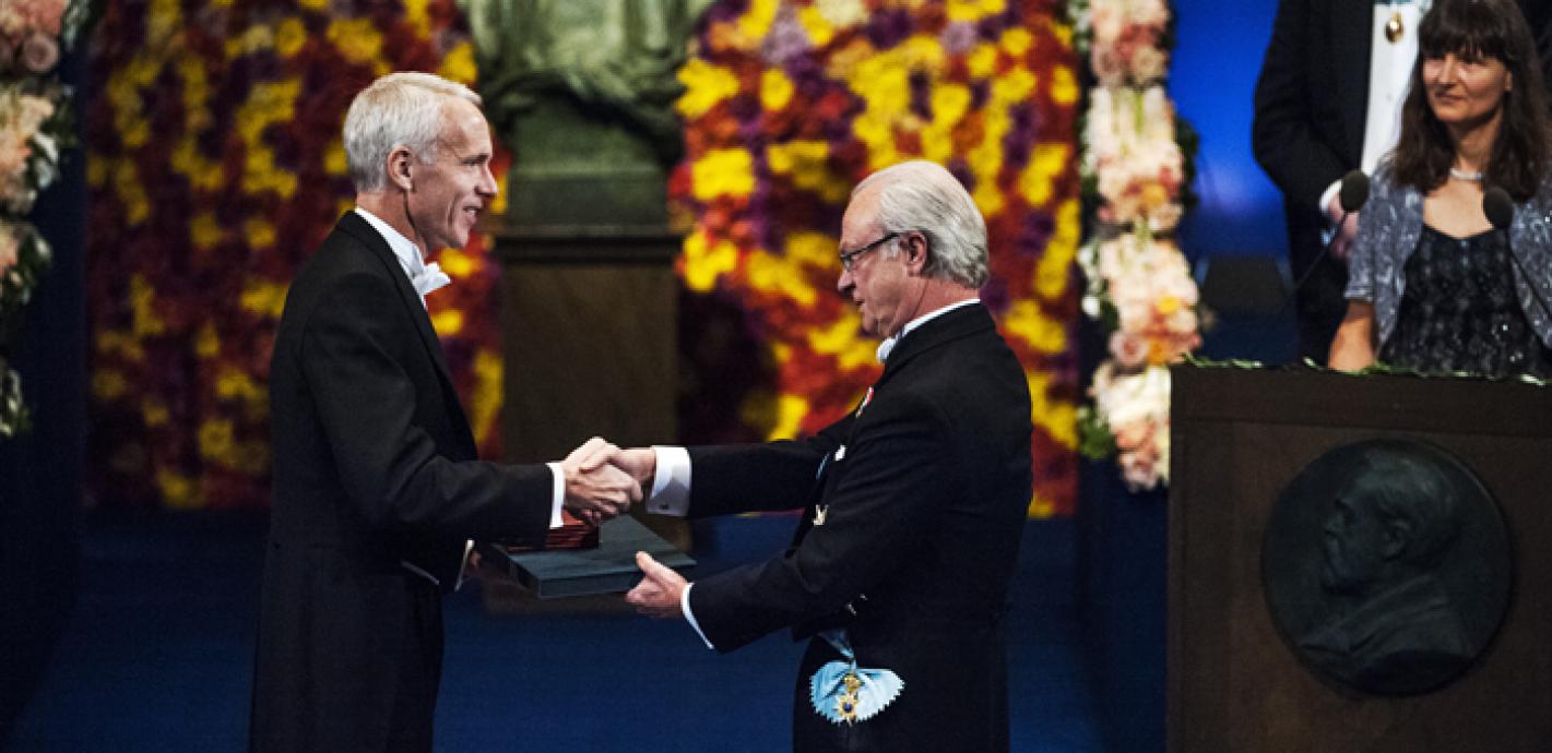 Brian Koblika mottar nobelmedaljen av kung Carl XVI Gustav