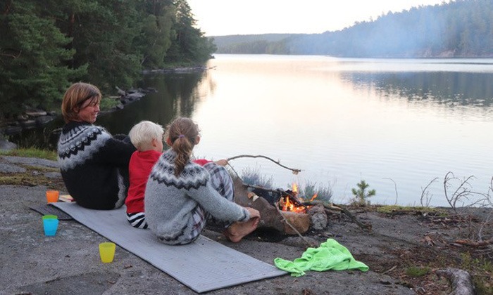Curies nya bloggare Annika Andersson sittandes vid en sjö med sina barn.