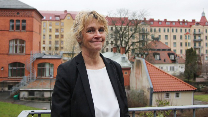 Helena Lindholm med gamal stadshus bakom sig. 
