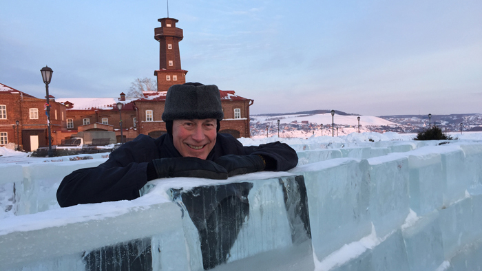 Alastair Creelman står och hänger över ett staket av is  