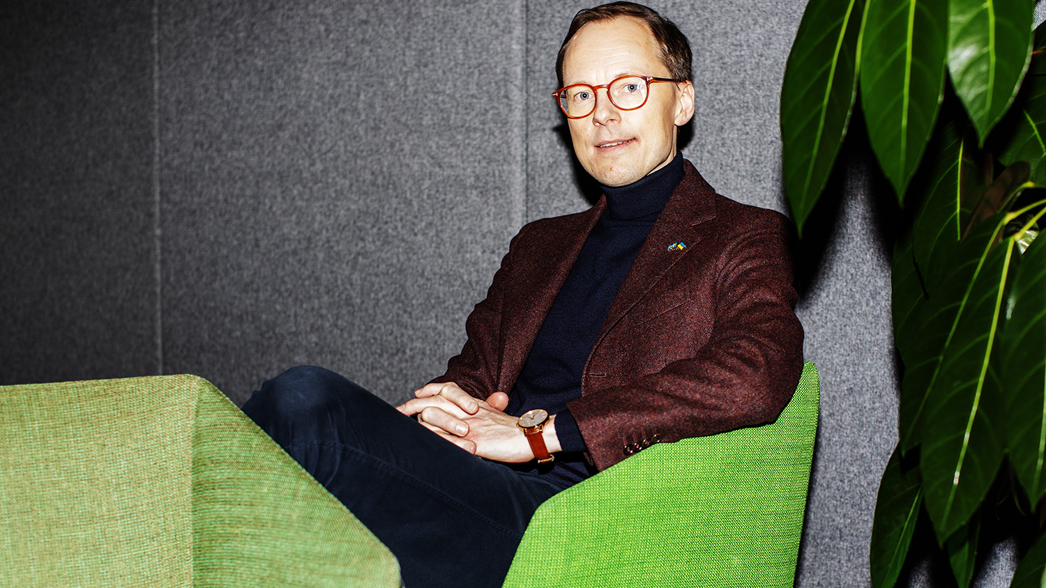 Mats Persson sitter i en grön fåtölj mot en grå vägg.