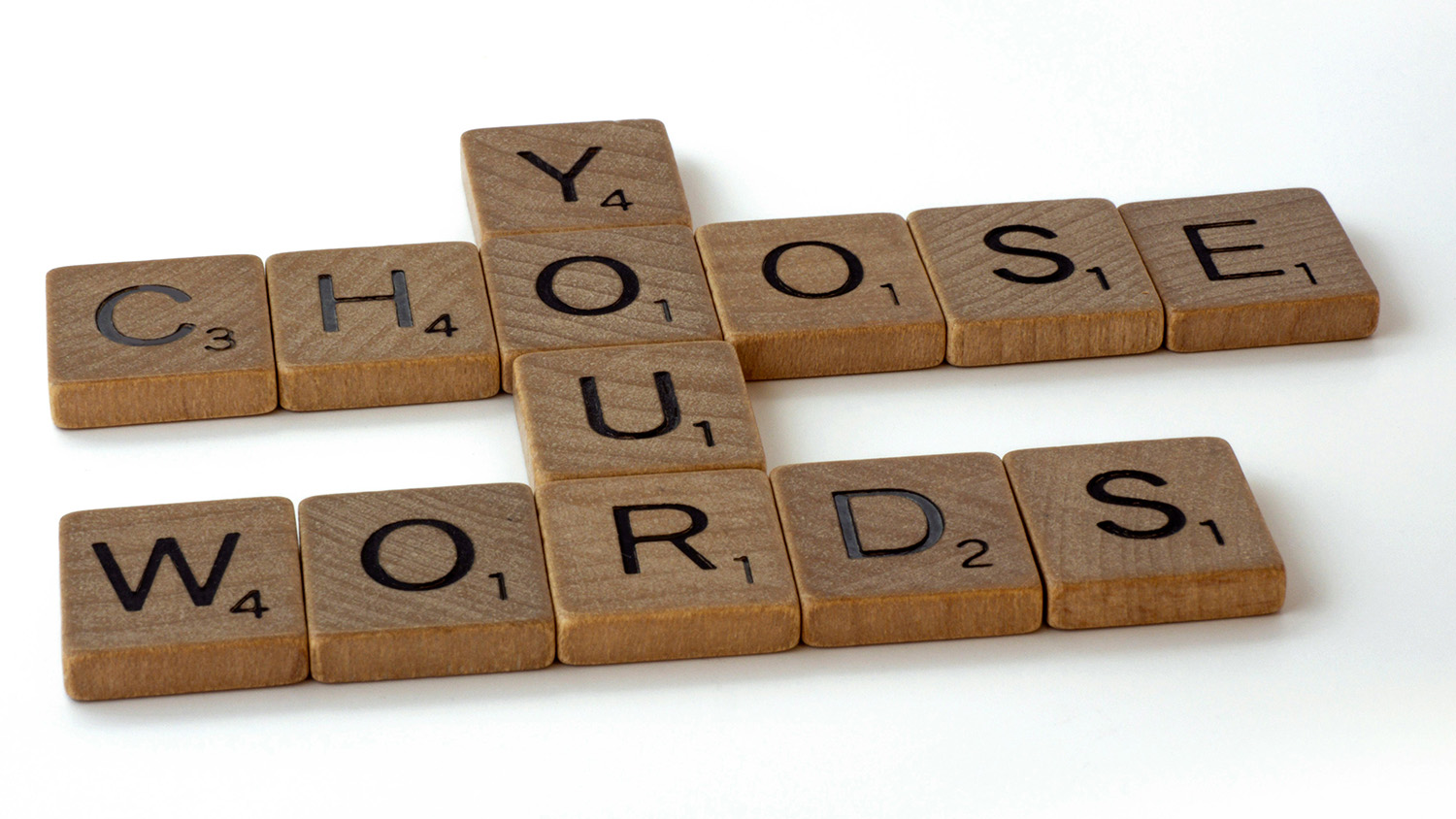 Små träbrickor med bokstäver formar meningen "Choose your words"