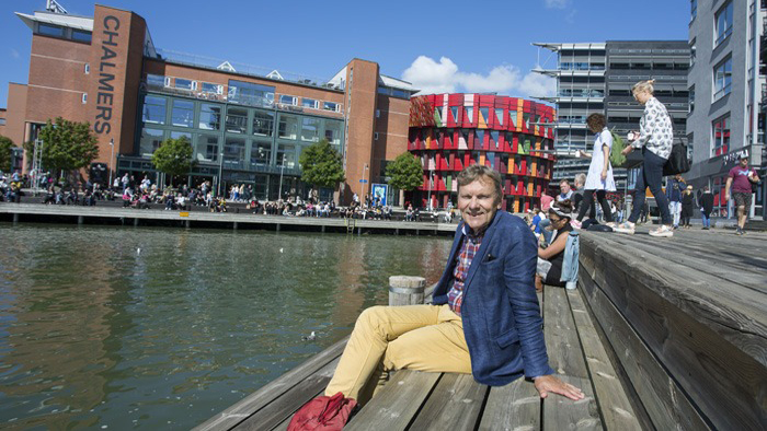 Sven Engström sitter vid vattnet framför Chalmers tekniska högskola.