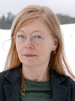 Porträttbild. Maria Hellström Reimer har långt, rakt, rött hår och tunna glasögon.