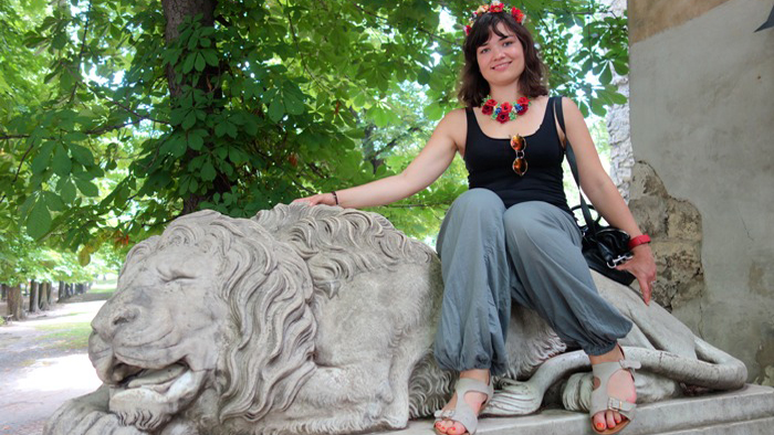 Margarita Bartish sitter i en park på en staty av ett lejon.
