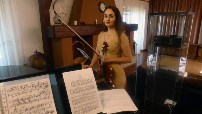Närbild på Beatriz Villarroel bakom flygel med fiol i handen. 