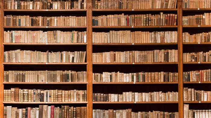 Stor bokhylla med många gamla böcker. 