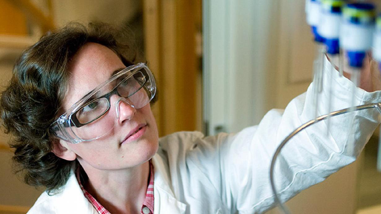 Kvinna med skyddsglasögon på labb.