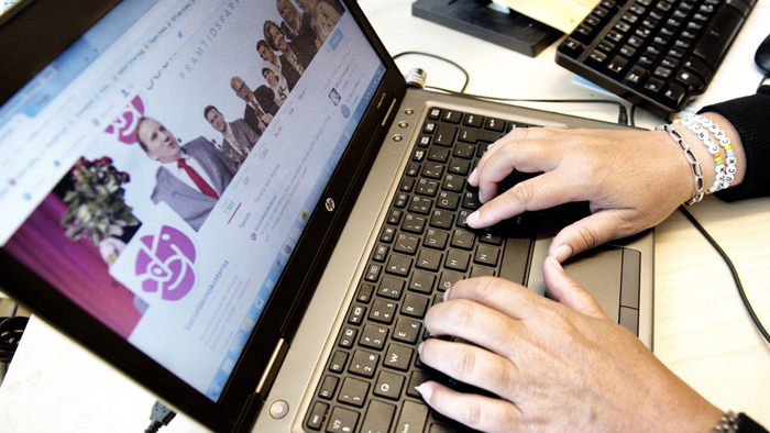 Händer som knappar på tangentbordet på
en laptop som visar Socialdemokraternas webbplats