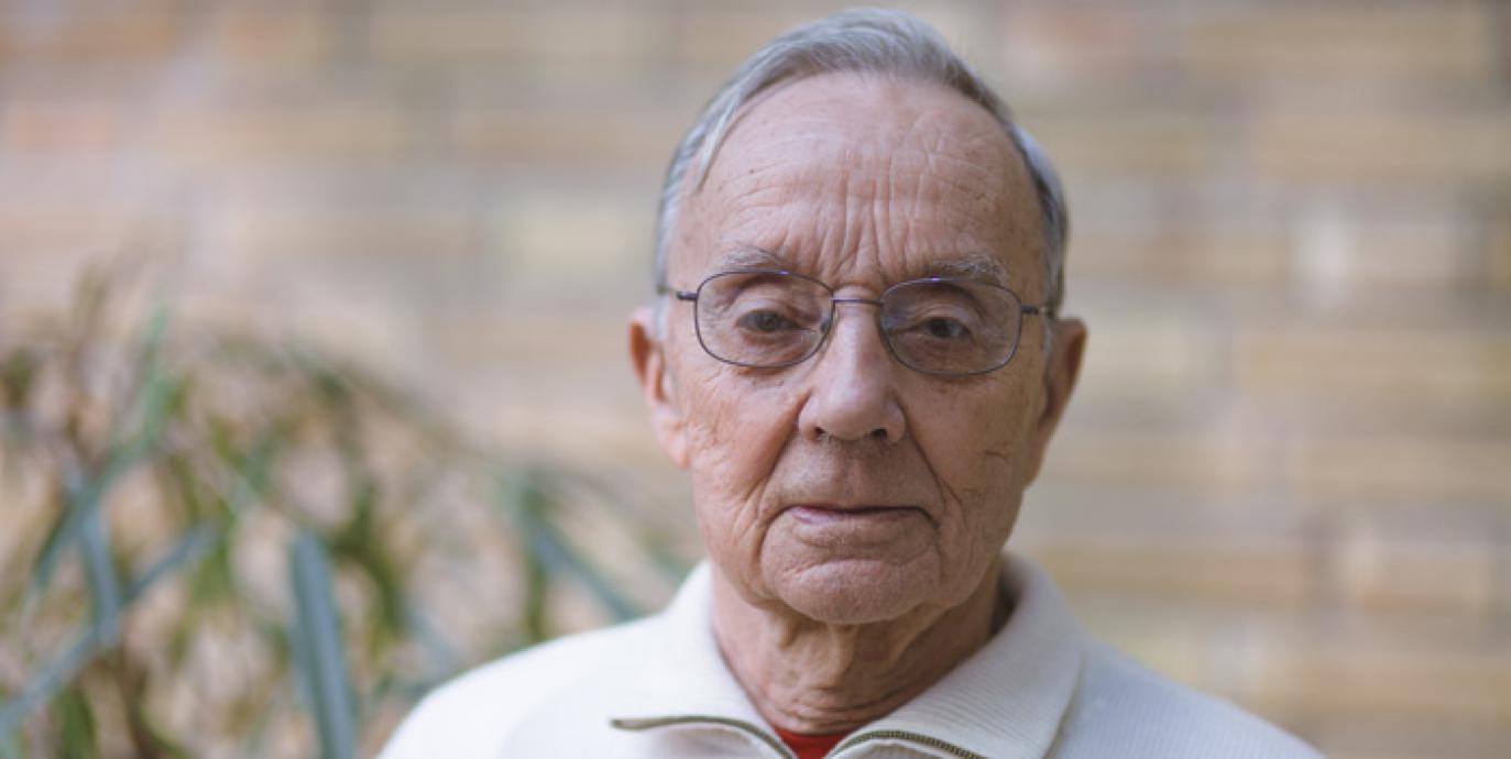 En äldre gråhårig man med glasögon