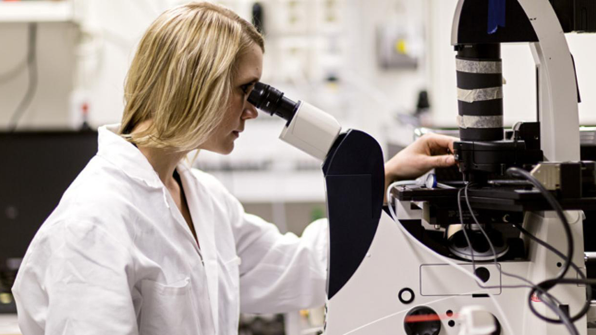 Anna-Karin Gustavsson tittar i mikroskop på labbet.