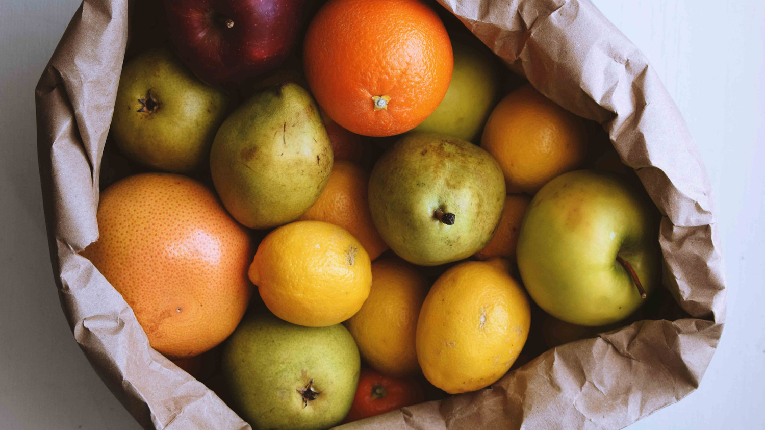 säck med äpplen, päron och andra frukter